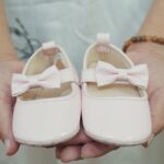 buty dla dziewczynki trzymane w rękach