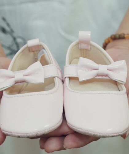 buty dla dziewczynki trzymane w rękach
