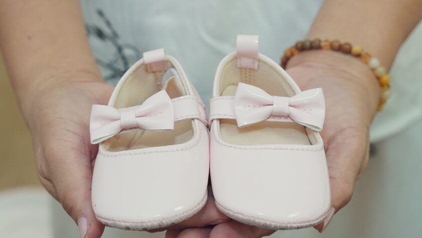 buty dla dziewczynki trzymane w rękach