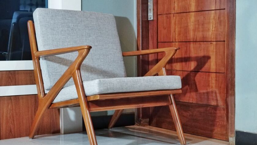 Fotel o drewnianej konstrukcji z szarą tapicerką w stylu mid-century modern