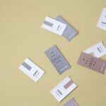 Kolorowe papierowe metki odzieżowe z symbolami prania rozrzucone na beżowym tle